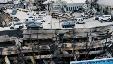 대형 화재 현장에서 검은 연기가 치솟고 소방대원들이 긴급 진압을 시도하는 장면